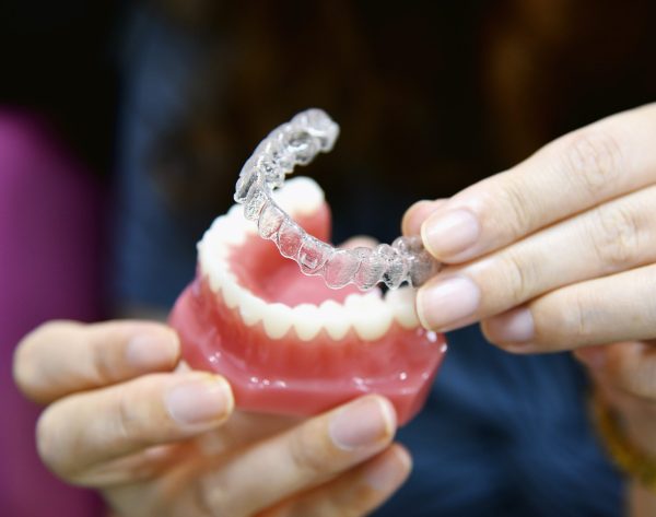 Inivisalign braces or aligner. Dentist advice how invisible orthodontics make beautiful teeth in dental clinic.